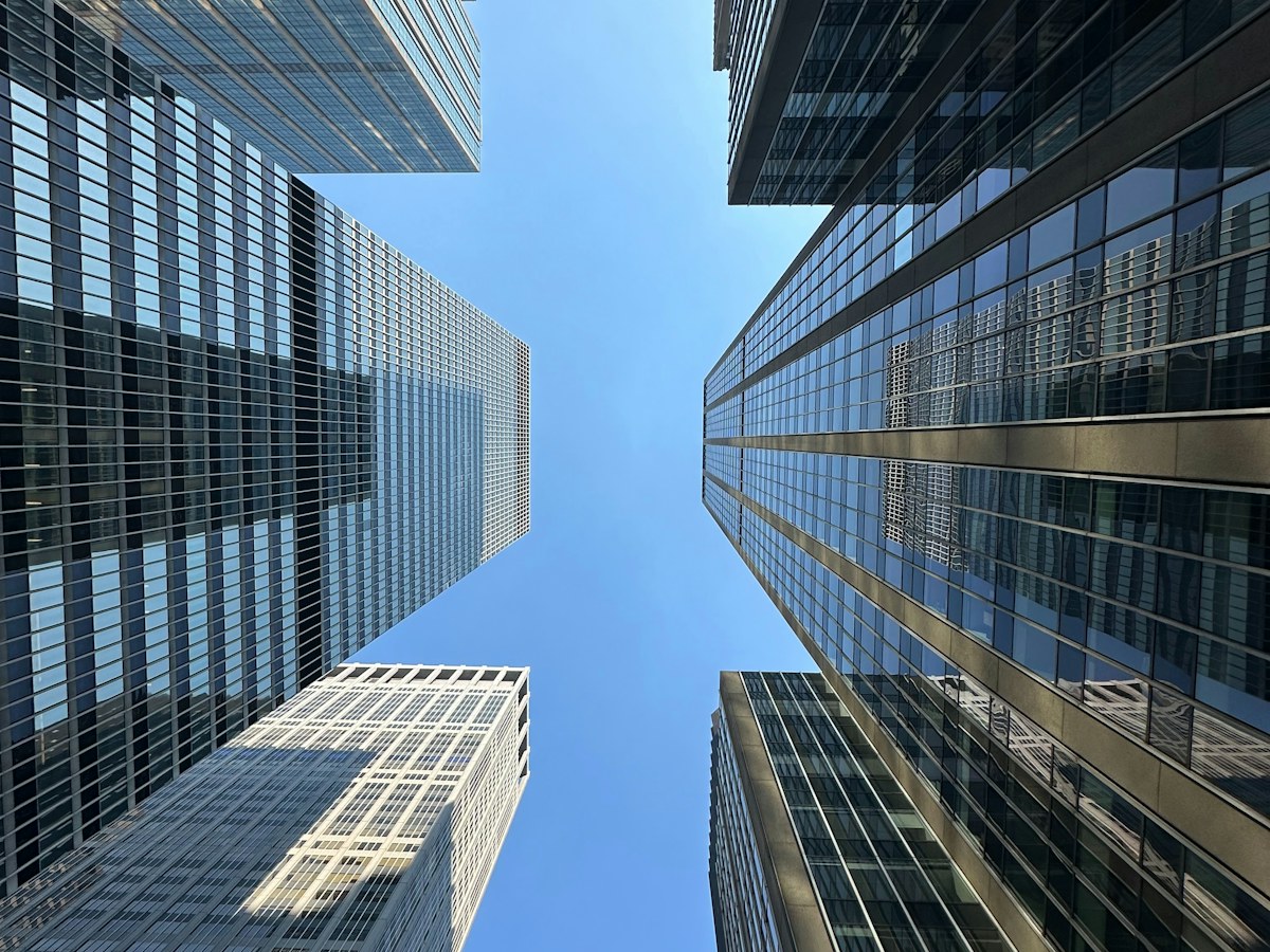 Looking upward between glass skyscrapers in Manhattan